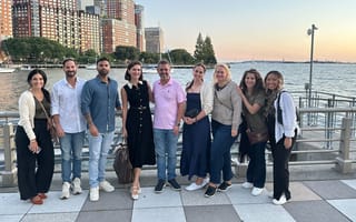 Nine Sisense team members posing for a group photo at a waterfront