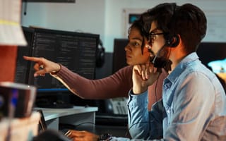 Two software engineers collaborate on a project in an office