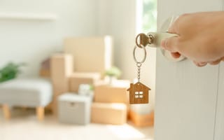 A person opening a door using a house key is shown.