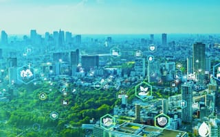 A cityscape with skyscrapers and greenery, overlaid with digital eco-friendly icons like trees, solar panels and recycling.