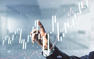 A hand in a suit adjusts a virtual graphical interface of rising bar and line charts, symbolizing financial growth and data analysis.