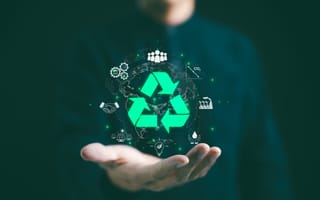 Hand of a businessman featuring recycling symbols on a dark background, representing a commitment to environmental responsibility.