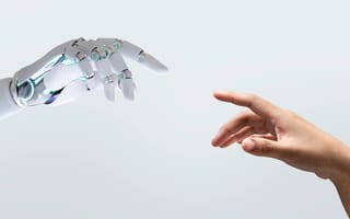 Robot hand and human hand reaching out to touch each other.