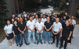 More than a dozen VFlowTech employees wearing white and black shirts stand together for a photo.