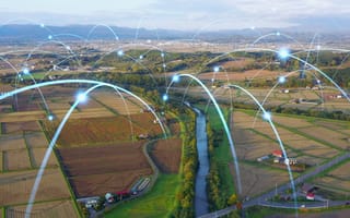 A series of digital arcs connect fields and farms, representing next-gen technologies in agriculture.