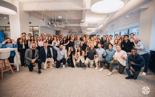 Mirakl team members pose for a large group photo in the company's office