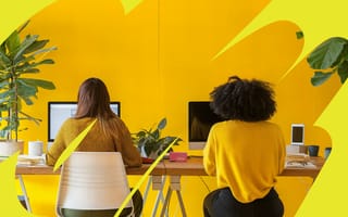 Two team members work at a long table in the company’s office