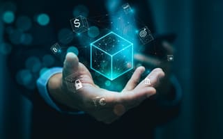 A digital cube illustration hovers over a hand surround by dollar sign and padlock icons to represent blockchain and crypto technology.