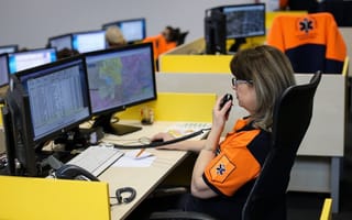 An emergency call operator is pictured talking into a receiver.