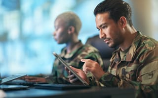 A soldier works on a tablet.
