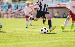 Kids are pictured playing soccer on a field.
