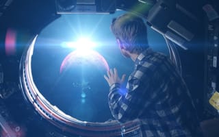 Image of a man looking out of the window of a spaceship, as if he's looking out the window of a plane.