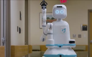 Diligent's humanoid robot, Moxi, with a friendly digital face in a hospital hallway.