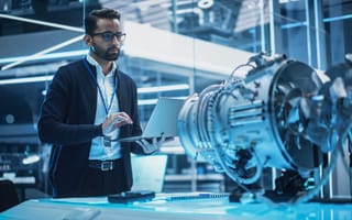 An image of an aerospace professional working on an aircraft component is shown.