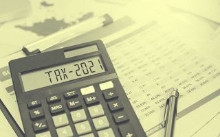 A yellow-toned image of a calculator displaying "TAX-2021." small-business-startup-tax-credit