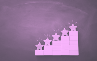 A purple-toned image of building blocks arranged in ascending steps, each topped with a star-shaped block 5-qualities-success-sales-engineering