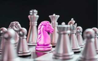 Chess pieces, with a pink knight. b2b saas positioning