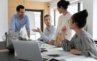A sales team meets around a table