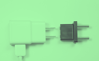 A green-toned image of a USB adapter and another international plug adapter. /remote-work/5-ways-remote-teams-must-adapt