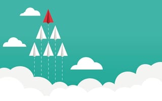 one red paper airplane leads a group of white paper airplanes upward through clouds