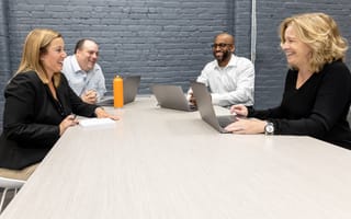 Interactions team members laughing together in company office