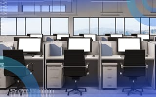 An image of many rows of cubicles with blank computer monitors with no one seated at them. /recruiting/4-ways-to-fill-tech-hiring-demand