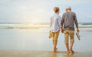retired couple walking beach