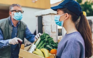 A woman holds a box of donated produce.