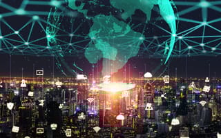 City at night with tech symbols above buildings