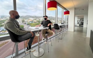 Dave teammates discussing strategy while wearing masks in company office