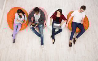 Young people sit in beanbags using gadgets