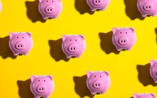 An overhead view of rows of pink piggy banks looking toward the viewer against a yellow background.