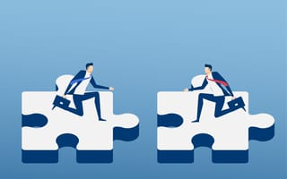 Two different team members trying to make puzzle pieces fit together.