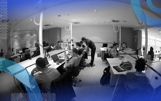 A group of software developers work in an open-plan office