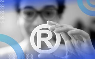 A woman holds a trademark symbol.
