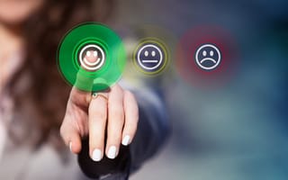 Businesswoman pressing smiley face emoticon on virtual touch screen
