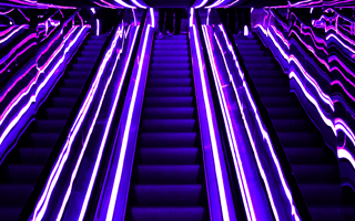 Multiple escalators with a lit passage to the top.