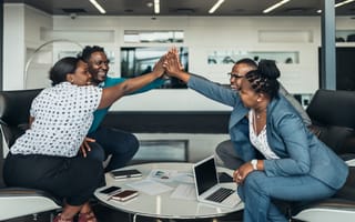Employees high-fiving in celebration.