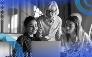 An older woman points something out on a computer screen to two younger women seated in front of her. /women-tech/5-advice-effective-stem-mentor
