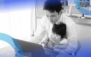 A worker uses a laptop while holding a baby