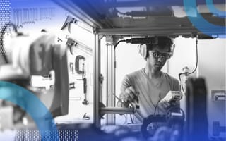 A young Black man conducts diagnostics on a manufacturing robot. /operations/upgrade-enterprise-asset-management-system