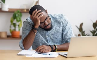 An employee holds his head in his hands in evident frustration.