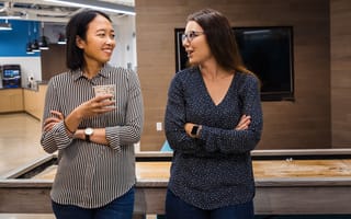 Two Alteryx team members chatting in the office