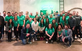 SouceDay team photo with a SourceDay neon sign