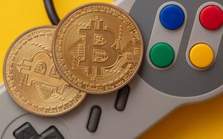 A game controller with cryptocurrency on top of it representing GameFi.