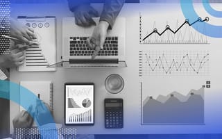 A table with researchers using charts, a tablet, and laptop.