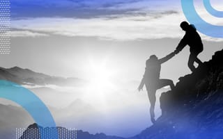 A climber helps another summit a mountain