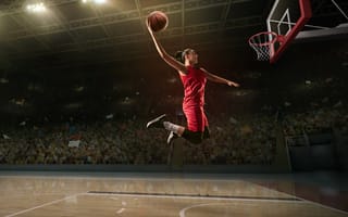 A female basketball player making a slam dunk
