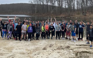 Boom Entertainment group photo on the sand by a lake