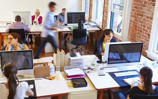 Wide angle view of a busy office with workers at desks